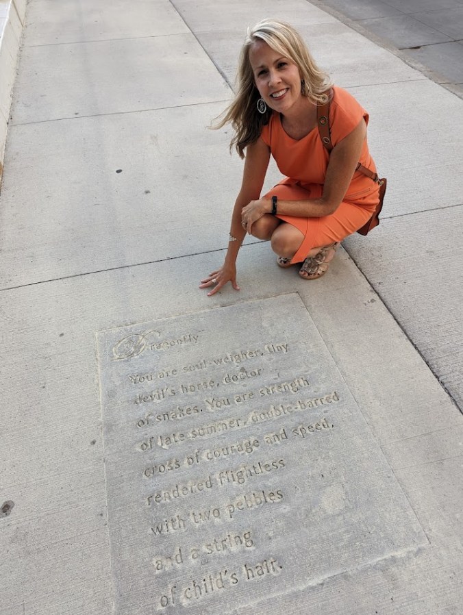 Paige Riehl&rsquo;s poem Dragonfly stamped in a sidewalk, close-up view
